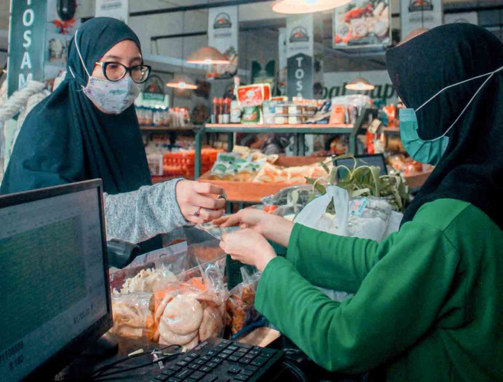 Indonesian customer giving money to Indonesian cashier